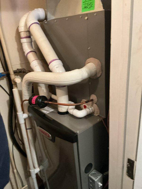 Performed comprehensive AC tune-up and furnace maintenance on 4-year-old Lennox system. Inspected indoor air handler unit with condensate pump assembly and verified proper drainage through PVC condensate lines. Evaluated outdoor condenser unit, checked refrigerant lines and electrical connections, and cleared vegetation growth from around unit base and concrete pad. Confirmed system operating properly and provided air filter to customer as requested.