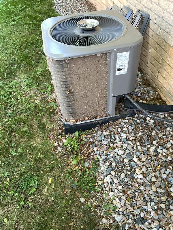 Completed scheduled air conditioning maintenance on outdoor condenser unit. Cleaned condenser coils which had significant accumulation of dirt, dust, and debris on heat exchange fins. Replaced air filter and inspected pad placement. Unit was surrounded by landscaping rock with some vegetation growth near base. Verified proper operation of fan assembly and checked refrigerant lines. System restored to optimal operating condition following standard preventive maintenance protocols.