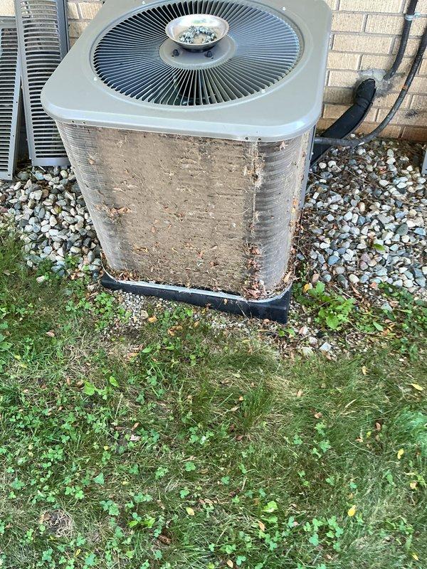 Completed scheduled air conditioning maintenance on outdoor condenser unit. Cleaned condenser coils which had significant accumulation of dirt, dust, and debris on heat exchange fins. Replaced air filter and inspected pad placement. Unit was surrounded by landscaping rock with some vegetation growth near base. Verified proper operation of fan assembly and checked refrigerant lines. System restored to optimal operating condition following standard preventive maintenance protocols.
