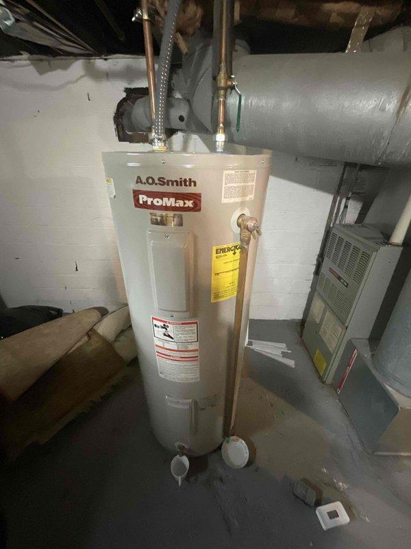 Responded to estimate request for A.O. Smith ProMax water heater experiencing discharge from temperature and pressure relief valve. Upon inspection, confirmed active dripping from T&P relief valve, indicating potential overheating condition or excessive pressure buildup in the system. Documented that unit is operating beyond manufacturer's expected service life as previously noted during home inspection. Evaluated overall condition of water heater including copper supply lines, flex connectors, and relief valve installation. Photographed equipment configuration and current plumbing connections for estimate preparation. Provided comprehensive replacement estimate given age of unit and active T&P valve discharge, which typically indicates internal tank deterioration or thermostat malfunction requiring full unit replacement rather than repair.