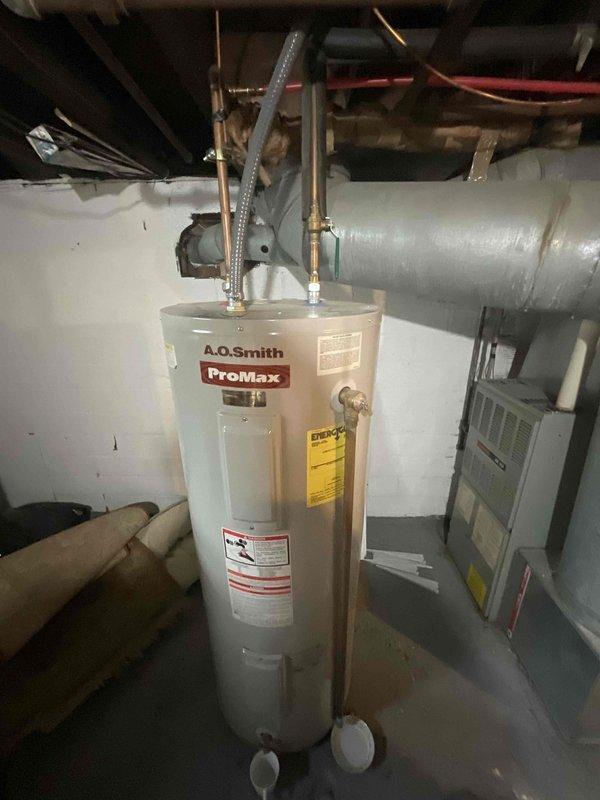 Responded to estimate request for A.O. Smith ProMax water heater experiencing discharge from temperature and pressure relief valve. Upon inspection, confirmed active dripping from T&P relief valve, indicating potential overheating condition or excessive pressure buildup in the system. Documented that unit is operating beyond manufacturer's expected service life as previously noted during home inspection. Evaluated overall condition of water heater including copper supply lines, flex connectors, and relief valve installation. Photographed equipment configuration and current plumbing connections for estimate preparation. Provided comprehensive replacement estimate given age of unit and active T&P valve discharge, which typically indicates internal tank deterioration or thermostat malfunction requiring full unit replacement rather than repair.