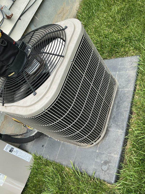 Completed comprehensive air conditioning maintenance on residential cooling system estimated at 5-7 years old. Upon arrival, addressed customer concerns regarding potential damage to unit exterior. Performed complete AC tune-up including inspection of condenser unit, fan assembly, and all exterior components. Verified system operational status and confirmed proper placement on concrete pad with adequate clearance. Inspected electrical conduit, wiring connections, and PVC refrigerant lines for integrity. Examined metal grille panels and horizontal fins for debris or damage. Tested fan motor operation and verified protective top guard securely in place. Checked mounting stability on foundation and assessed overall equipment condition. Unit found to be in functional condition with no significant damage observed despite initial concerns. All components operating within normal parameters at time of service completion.