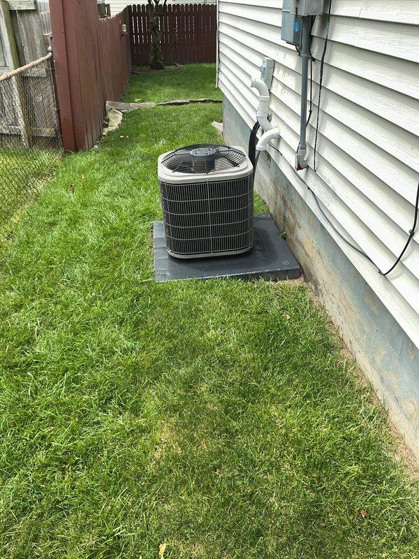 Completed comprehensive air conditioning maintenance on residential cooling system estimated at 5-7 years old. Upon arrival, addressed customer concerns regarding potential damage to unit exterior. Performed complete AC tune-up including inspection of condenser unit, fan assembly, and all exterior components. Verified system operational status and confirmed proper placement on concrete pad with adequate clearance. Inspected electrical conduit, wiring connections, and PVC refrigerant lines for integrity. Examined metal grille panels and horizontal fins for debris or damage. Tested fan motor operation and verified protective top guard securely in place. Checked mounting stability on foundation and assessed overall equipment condition. Unit found to be in functional condition with no significant damage observed despite initial concerns. All components operating within normal parameters at time of service completion.
