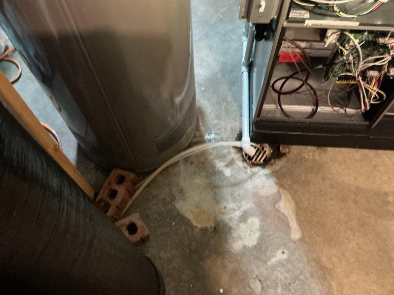 Completed full HVAC system installation including a 70,000 BTU furnace with humidifier, 2.5-ton air conditioning unit with evaporator coil in rear-discharge configuration. Successfully reconnected all electrical and refrigerant lines, installed ductwork connections, and verified proper system operation with condensation forming on the air handler indicating cooling mode functionality.