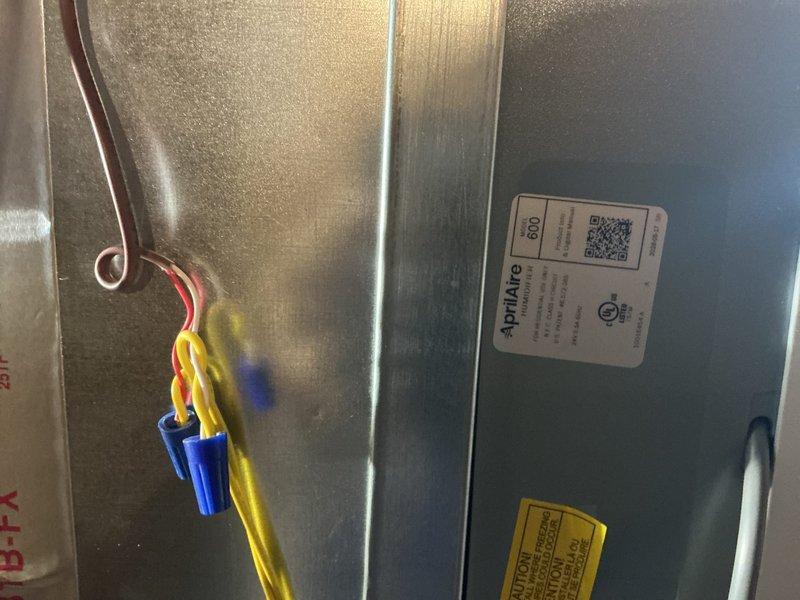 Completed full HVAC system installation including a 70,000 BTU furnace with humidifier, 2.5-ton air conditioning unit with evaporator coil in rear-discharge configuration. Successfully reconnected all electrical and refrigerant lines, installed ductwork connections, and verified proper system operation with condensation forming on the air handler indicating cooling mode functionality.