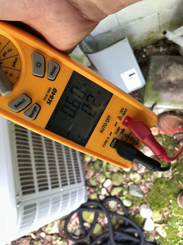 Responded to service call for 2-year-old air conditioning system not cooling home adequately. Performed diagnostic evaluation of outdoor condenser unit located in garage area. Assisted with installation of new air filter provided on-site. Conducted electrical testing and measurements using digital multimeter to verify system performance and identify potential issues affecting cooling capacity. Documented readings and system conditions with diagnostic photos for service records.