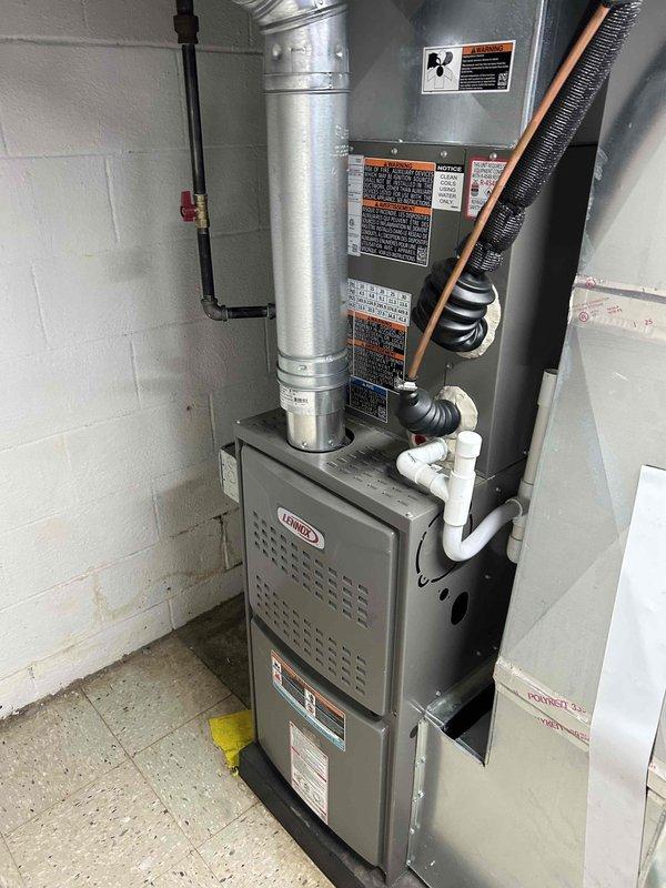 Responded to service call for newly purchased home with reported inadequate cooling performance on 1-year-old Lennox HVAC system. Upon arrival, found Sensi thermostat set to 50°F in cooling mode with ambient temperature reading 79°F, indicating improper thermostat programming. Inspected indoor air handler and furnace unit located in basement utility area; verified all mechanical components, refrigerant lines, and condensate drainage system operating within normal parameters. Provided thermostat operation tutorial, demonstrated proper temperature setpoint adjustment, mode selection, and scheduling functions. Inspected filter cage accessibility as requested and confirmed filter removal process. Verified system operation under proper settings; unit cooling effectively once thermostat correctly programmed. Checked water heater status per homeowner request. System under parts and labor warranty coverage.