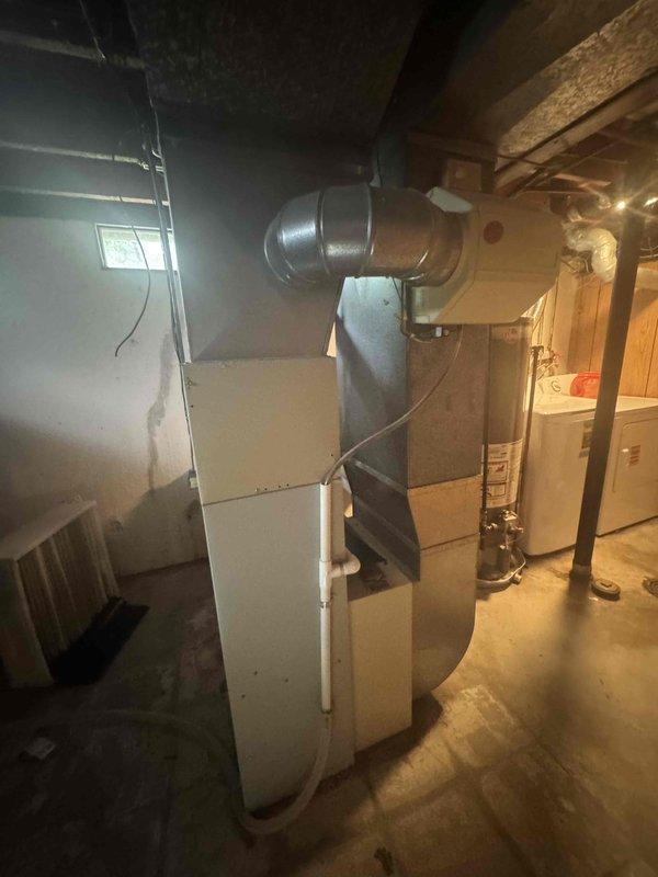 Provided estimate for air conditioning system replacement in basement utility area. Current 20+ year old A/C unit is non-operational and requires full replacement. Assessed existing HVAC infrastructure including furnace, ductwork configuration, and available space for new equipment installation.