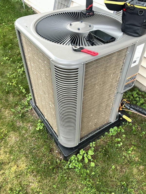 Responded to service call for newly installed AC system experiencing water leakage and reduced cooling capacity. Upon arrival, performed diagnostic evaluation of outdoor condenser unit and system operation. Removed top fan grille to access and inspect condenser fan assembly and internal components. Conducted pressure and temperature measurements using digital diagnostic equipment, which revealed a suction line reading of -19, indicating potential refrigerant flow issues or low charge condition. Inspected drain line system and condensate removal components to identify source of water leak. Evaluated overall system performance and documented findings with photographic evidence of equipment condition and diagnostic readings. System assessed for potential installation defects or component failures given unit's age and history of repeated service issues. Recommended follow-up actions to address underlying cause of recurring problems with this new installation.