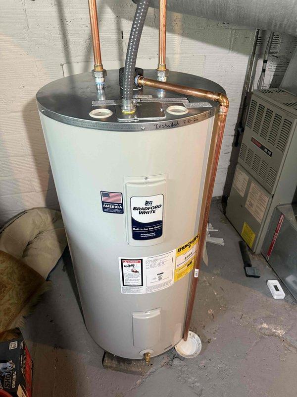 Installed Bradford White tanked water heater model RE350S61NCWW in residential basement utility room. Connected copper supply lines and discharge piping to existing plumbing infrastructure, positioned unit on drain pan per code requirements, and verified all connections for proper operation. Mechanical permit was obtained prior to installation for hot water tank reconnection work.