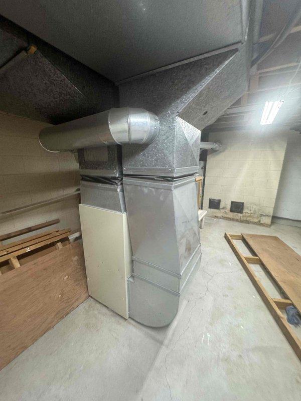 Conducted comprehensive on-site evaluation of existing 16-year-old residential HVAC system including air conditioning unit and furnace located in basement mechanical room. Performed thorough inspection and documentation of current equipment configuration, ductwork layout, and system components to provide accurate full system replacement estimate. Photographed existing furnace with beige cabinet housing, air handler assembly, galvanized supply plenum, and associated ductwork routing for replacement specifications and equipment sizing requirements.