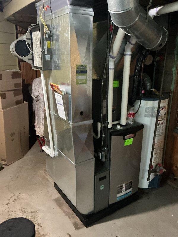 Completed annual cooling maintenance on residential HVAC system in basement mechanical room. Inspected furnace unit, ductwork, and humidifier assembly; removed and examined humidifier evaporator pad showing mineral deposits and discoloration from normal use. All system components, electrical connections, and ductwork found to be in proper working condition with no immediate service needs identified.