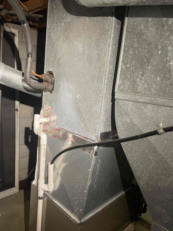 Provided estimate for replacement of approximately 15-year-old air conditioning system located in basement, currently non-operational due to suspected refrigerant leak and equipment age making repair uneconomical. Assessed existing setup including gas furnace, ductwork showing significant condensation, and current system configuration with condensate drainage components. Documented equipment condition and discussed replacement options for complete air conditioning system compatible with existing natural gas heating infrastructure.