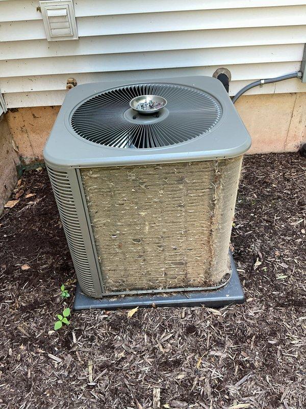 Completed comprehensive ComfortGuard Maintenance Package on residential outdoor air conditioning condenser unit. Performed standard preventive maintenance procedures including system inspection, cleaning of exterior components, and verification of proper operation. Unit showed significant environmental weathering and organic debris accumulation on exterior panels, which is typical for outdoor equipment exposure; documented existing cosmetic condition with photographs for service records.
