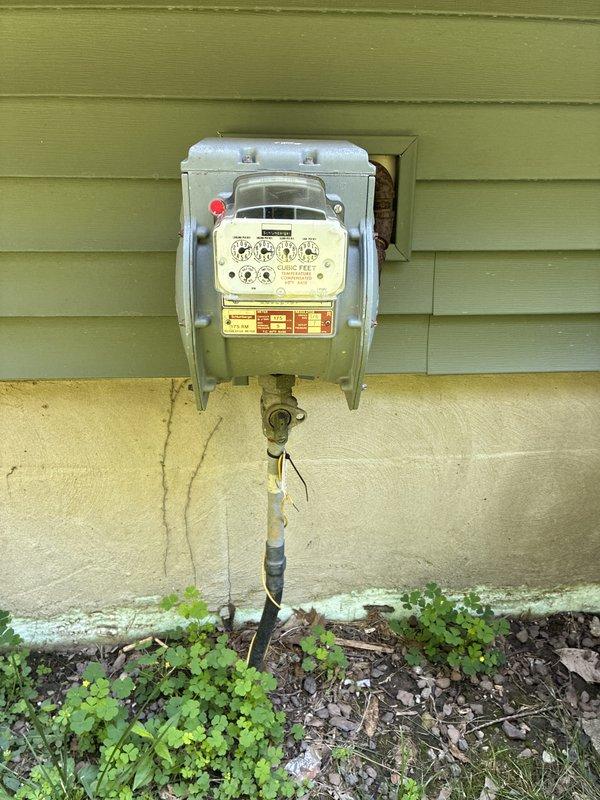 Conducted comprehensive site assessment for whole-home standby generator installation with focus on Kohler system specification. Evaluated existing electrical service, natural gas meter infrastructure, and load requirements including deep-well water pump, central air conditioning, electric range, and power-vented gas water heater. Documented current utility connections and meter locations through photographic survey of electric and gas meter installations on exterior wall. Analyzed client's specific power quality concerns regarding frequent brownouts, voltage sags, and grid flickering conditions requiring automatic transfer switch with voltage protection capabilities for sensitive electronics and appliances.