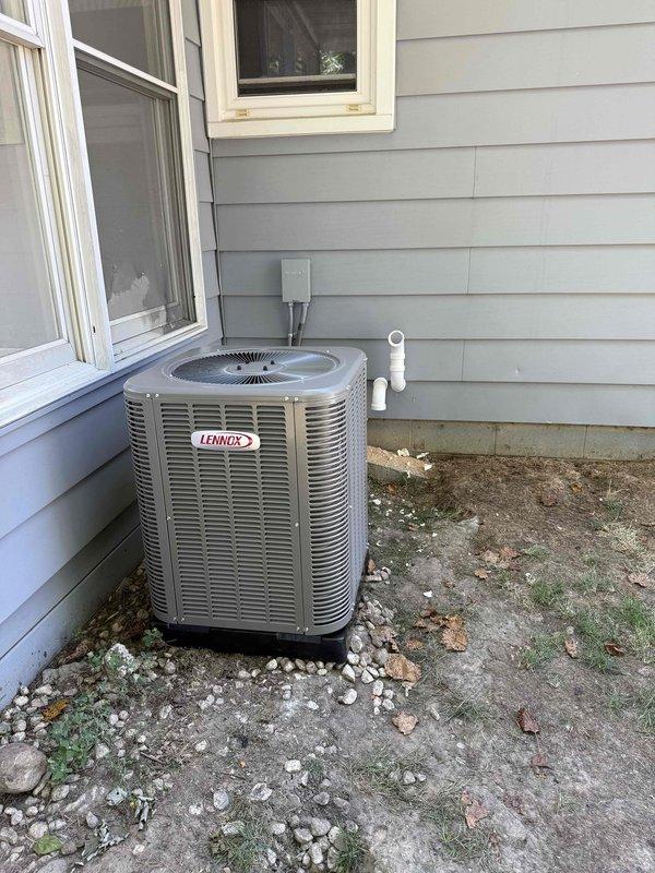 Completed full HVAC system installation including a 70,000 BTU furnace, 2-ton air conditioning condenser unit, and evaporator coil. The Lennox outdoor condenser was positioned on existing concrete pad at rear of residence with proper refrigerant line connections, condensate drainage, and electrical reconnection. Indoor furnace and coil were installed in utility room with all necessary ductwork connections, gas line hookup, and venting completed per code requirements.