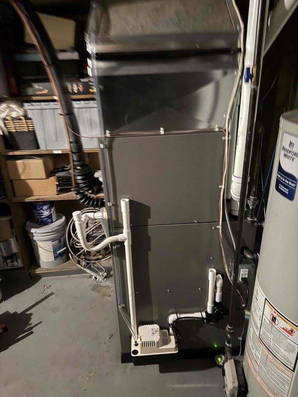 Completed full HVAC system installation including a 70,000 BTU furnace, 2-ton air conditioning condenser unit, and evaporator coil. The Lennox outdoor condenser was positioned on existing concrete pad at rear of residence with proper refrigerant line connections, condensate drainage, and electrical reconnection. Indoor furnace and coil were installed in utility room with all necessary ductwork connections, gas line hookup, and venting completed per code requirements.