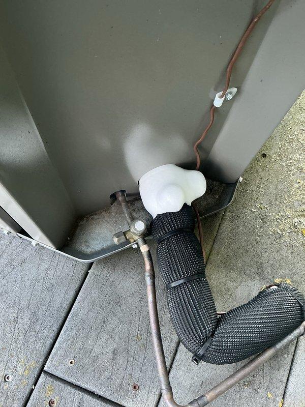 Performed inspection of outdoor condensing unit and indoor evaporator coil assembly. Examined copper refrigerant line connections, condensate drain system with float mechanism, and coil fin condition. Verified proper mounting and secure fastening of all components, with equipment showing normal operational wear and all mechanical elements properly installed and functional.