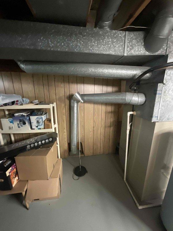 Conducted comprehensive full system estimate for replacement of 16-year-old air conditioning unit that experienced complete failure. Assessed existing HVAC infrastructure in basement utility area, including furnace, ductwork configuration, and air handler components. Documented current system layout with photographic evidence showing galvanized sheet metal ductwork, round metallic supply ducts, and equipment placement to provide accurate replacement specifications for immediate installation needs.