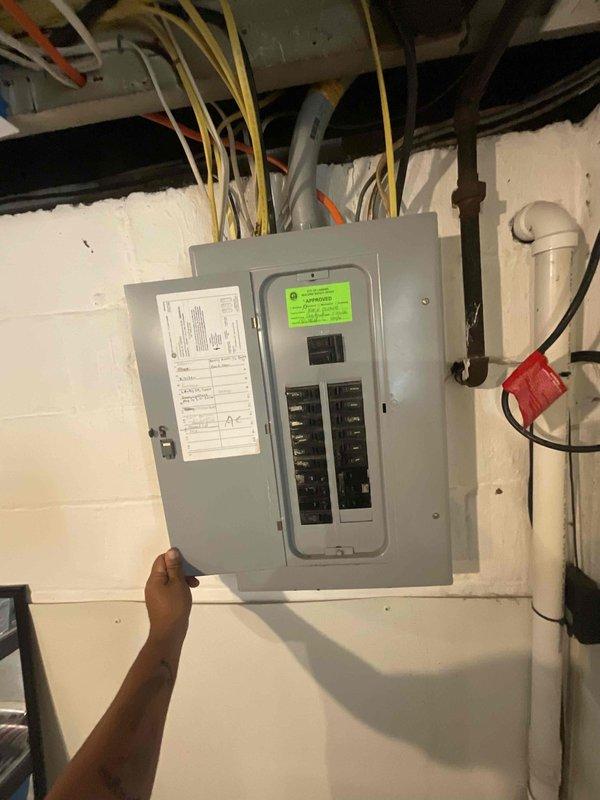 Conducted full system estimate for 16-year-old air conditioning unit located in unfinished basement area. Evaluated existing HVAC equipment, ductwork configuration, and electrical service panel to provide replacement recommendations for system nearing end of service life. Documented current installation with photographs for proposal preparation, noting standard basement setup with exposed joists, concrete flooring, and central furnace/AC configuration with overhead duct distribution.