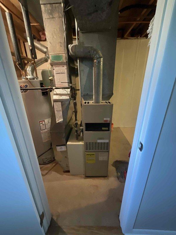 Conducted on-site evaluation for furnace replacement estimate. Assessed existing 20-year-old furnace system located in basement mechanical room alongside water heater. Documented current equipment configuration including ductwork layout, venting arrangements, and spatial considerations for replacement unit installation. Customer requesting replacement within three-month timeframe due to age of existing equipment.