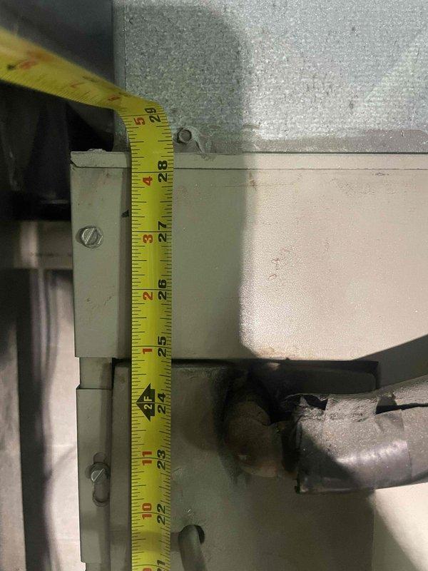 Provided estimate for air conditioning system replacement in basement location. Current unit is non-operational with unknown age. Performed measurements of existing equipment clearances and documented spatial requirements for new installation, including vertical clearances around metal housing and ductwork connections.