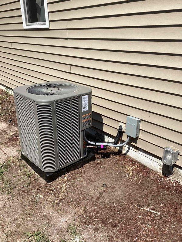 Completed installation of a 2-ton air conditioning system with matching evaporator coil at rear of residence. Installed new outdoor condensing unit on pad with refrigerant line set routed along exterior wall, mounted electrical disconnect box, and established new dedicated electrical circuit. Interior work included evaporator coil installation with PVC condensate drain line and trap configuration in basement utility area. All mechanical and electrical permits were obtained prior to installation, system was properly charged, tested for proper operation, and left running efficiently.