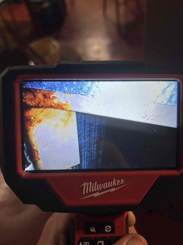 Responded to callback for water leak at furnace following previous visits and blower motor replacement. Upon arrival, utilized Milwaukee inspection camera to perform detailed internal examination of ductwork and furnace components. Inspection revealed moisture accumulation and potential condensation issues within the system. Camera inspection documented metallic surfaces showing visible water droplets and corrosion staining on galvanized ductwork, indicating ongoing moisture intrusion. Thoroughly examined HVAC components to identify source of persistent water leak issue and documented findings with photographic evidence for further assessment and resolution.