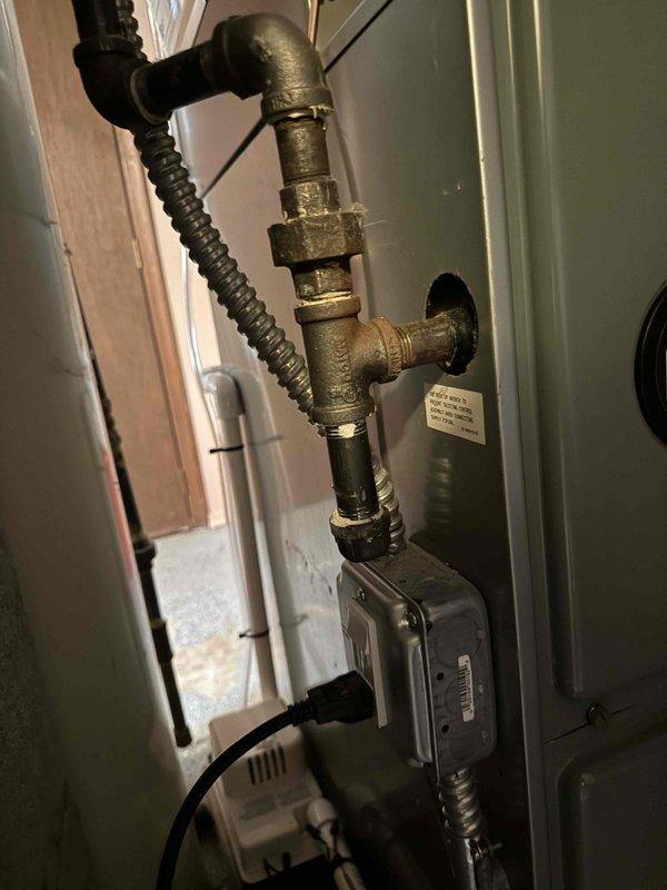 Completed installation of 2-ton air conditioning system with evaporator coil in residential basement mechanical space. New A/C unit positioned at rear location and reconnected to existing furnace system. Installation included proper refrigerant line connections, condensate drainage routing with electronic monitoring device, electrical connections, and integration with existing ductwork. All plumbing connections secured with brass fittings and flexible conduit runs installed per code requirements. System tested for proper operation and airflow distribution throughout residence.