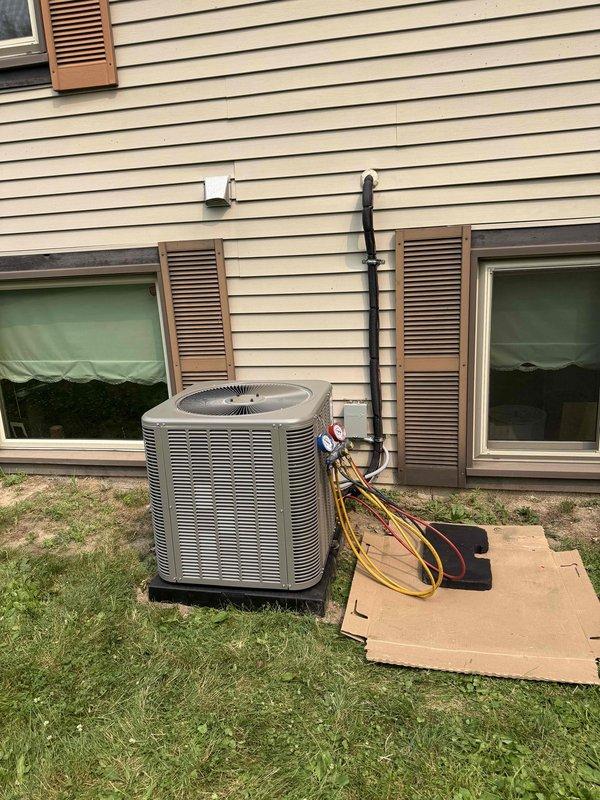 Completed full installation of 2.5-ton air conditioning system with evaporator coil at residential property. Installed outdoor condensing unit on rubber pad at rear of home with proper line-set routing and electrical conduit secured to exterior siding. Indoor evaporator coil installed in basement mechanical area with refrigerant lines connected and system charged. All mechanical and electrical permits obtained prior to installation, and system tested for proper operation upon completion.