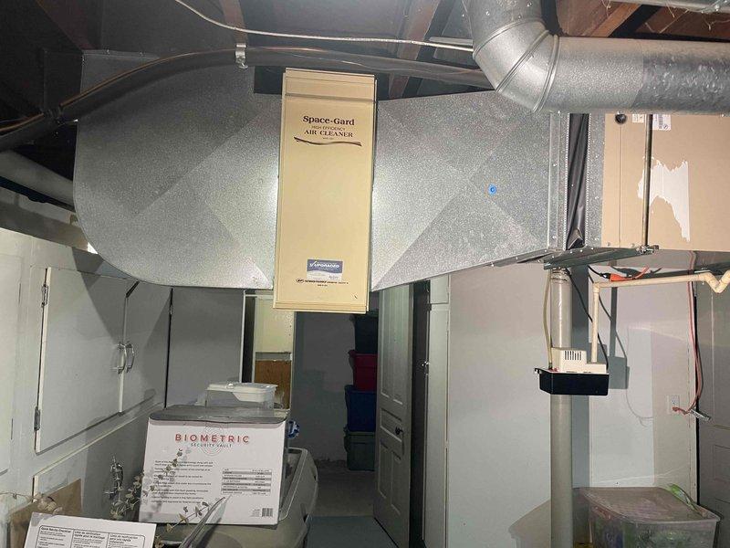 Provided estimate for complete air conditioning system replacement. Existing 30-year-old outdoor condenser unit shows extensive rust, corrosion, and weathering with compromised functionality. Basement-located air handling equipment includes integrated Space-Gard air filtration system. Assessed aging HVAC infrastructure and documented current equipment condition through comprehensive site photography to prepare replacement recommendations.