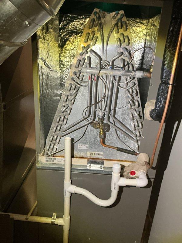 Completed comprehensive preventive maintenance on a two-year-old central air conditioning system operating within normal parameters. Performed full system inspection including evaporator coil assembly with reflective insulation, verified proper refrigerant line connections and securing, and inspected condensate drain system with PVC piping and shut-off valve for proper operation. Replaced air filter showing moderate dust accumulation to maintain optimal airflow and system efficiency. All components functioning as designed with no deficiencies noted.