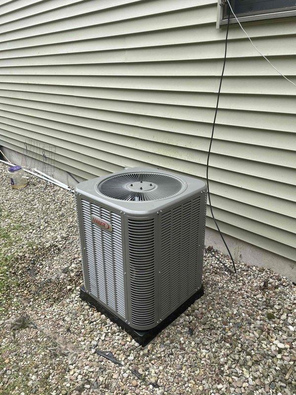 Completed installation of 2-ton Lennox air conditioning condensing unit with matching evaporator coil at rear of residence. Unit positioned on composite pad over gravel bed with proper clearance from structure, electrical disconnect installed and wired per code, refrigerant lines connected and system commissioned. All required permits obtained, system tested and left operational with proper airflow and temperatures.
