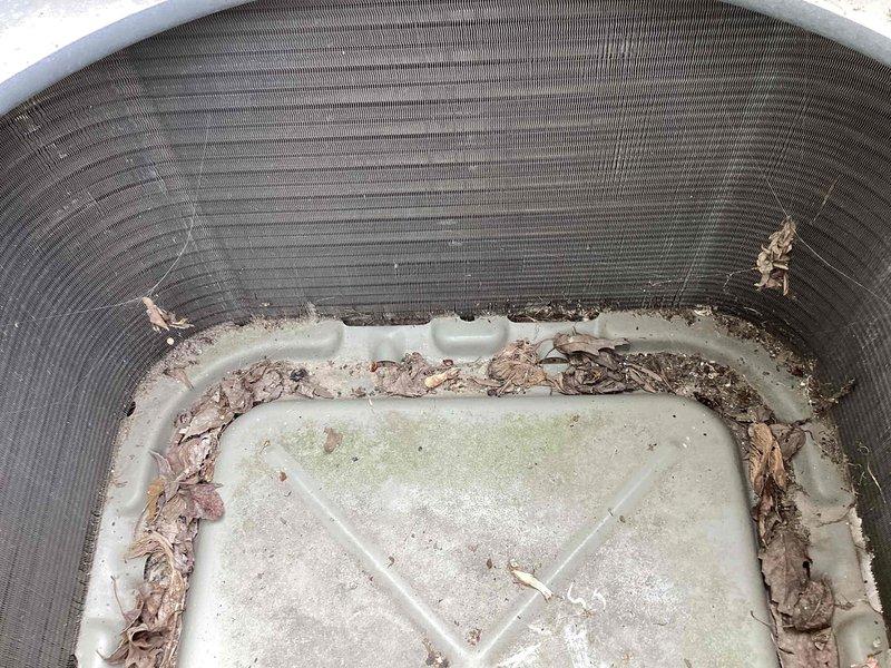 Completed annual maintenance on outdoor condensing unit. Removed accumulated debris, leaves, and organic matter from condensate drain pan and interior housing. Inspected fan grilles and refrigerant lines for proper operation. Unit operational upon completion of cleaning and inspection.