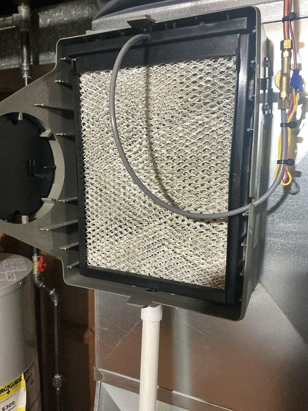 Completed annual HVAC maintenance inspection and documented system conditions. Observed heavy frost accumulation on refrigerant lines and U-bend copper tubing at the evaporator coil, indicating potential airflow restriction or refrigerant charge issues requiring further evaluation. Inspected and documented humidifier assembly with water panel evaporator in serviceable condition.