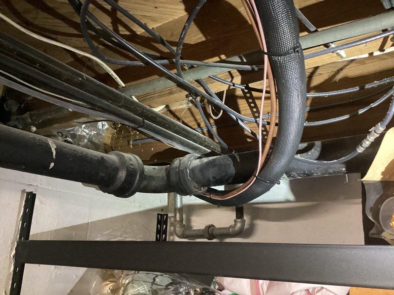 Completed installation of 2-ton air conditioning system with evaporator coil at rear location. Obtained mechanical and electrical permits prior to installation and established new dedicated electrical circuit to support the system. During installation, identified code violations including improper wire installation methods where conductors were stapled to floor joists rather than routed through bored holes, and non-compliant use of tandem breaker in electrical panel not rated for such configuration.