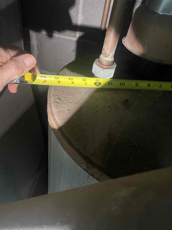 Conducted site assessment for replacement estimate of 30+ year old non-operational ground-level AC unit located behind building and potential natural gas furnace replacement. Documented existing equipment dimensions and installation space measurements in utility area to determine specifications for new HVAC system installation.