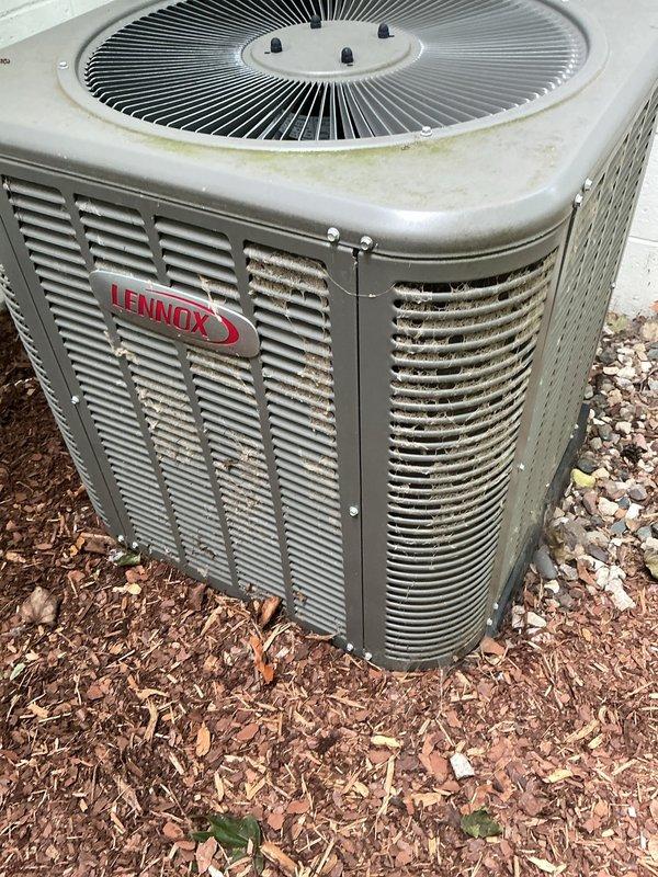 Completed comprehensive 5-year ComfortGuard maintenance service on Lennox outdoor condensing unit and indoor air handling system. Performed thorough inspection of outdoor unit, noting minor weathering and organic growth on top surfaces with debris accumulation between protective grilles. Cleaned condenser coils and removed webbing from side grille openings. Replaced evaporator cooling pads as requested specialty service. Inspected and serviced return air filter housing, addressing accumulated dust and debris on filter media. Verified proper airflow through ventilation grilles and confirmed system operational parameters within manufacturer specifications.