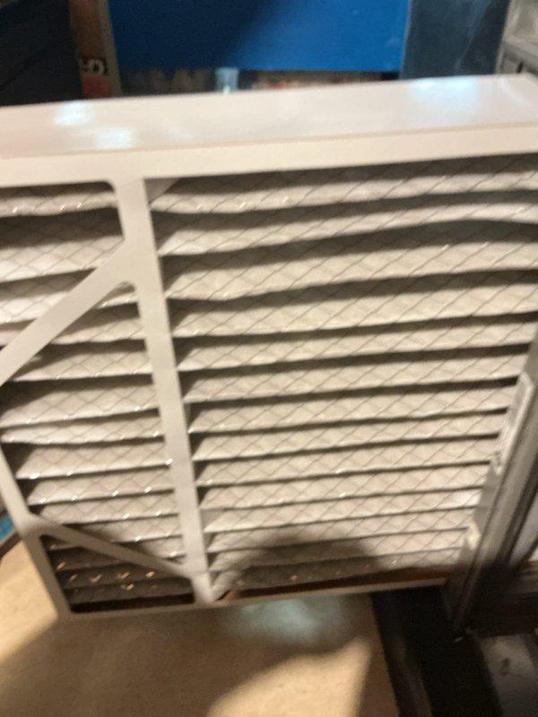 Completed comprehensive 5-year ComfortGuard maintenance service on Lennox outdoor condensing unit and indoor air handling system. Performed thorough inspection of outdoor unit, noting minor weathering and organic growth on top surfaces with debris accumulation between protective grilles. Cleaned condenser coils and removed webbing from side grille openings. Replaced evaporator cooling pads as requested specialty service. Inspected and serviced return air filter housing, addressing accumulated dust and debris on filter media. Verified proper airflow through ventilation grilles and confirmed system operational parameters within manufacturer specifications.