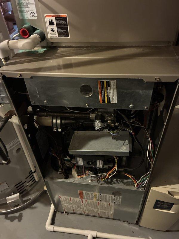 Conducted comprehensive assessment of existing HVAC system for complete replacement estimate. Inspected 20-year-old furnace unit, documenting internal components including blower motor assembly, control board, and electrical connections. Evaluated condition of air conditioning system of similar age. Both units have reached end of expected service life and require replacement to maintain reliable whole-house climate control. Photographed furnace interior showing typical age-related wear on components and electrical panel installation with associated ductwork and utilities. Provided detailed replacement recommendations for complete system upgrade.