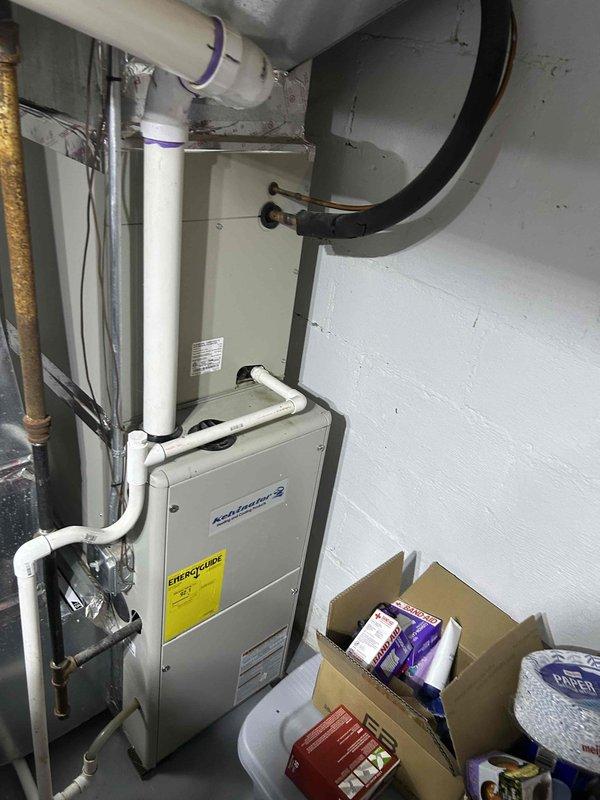 Responded to no-cool complaint with frozen evaporator coil on indoor furnace unit. Upon arrival, system had been shut down by customer and ice had melted. Inspected both indoor air handler in basement and outdoor condensing unit. Found system operational but not cooling adequately to setpoint. Identified restricted airflow as likely cause of coil freeze-up. Verified refrigerant lines, checked system operation, and documented equipment condition with photos. Recommended filter replacement and further diagnostics to determine underlying cause of inadequate cooling performance and prevent future coil icing.