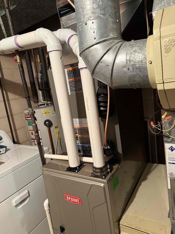 Successfully installed a 2.5-ton Bryant air conditioning system with matching evaporator coil in residential basement utility space. Installation included connecting copper refrigerant lines to existing furnace system, routing PVC condensate drainage lines, integrating new coil unit with existing ductwork, and completing all electrical connections. System was installed per manufacturer specifications with proper refrigerant line configuration and secured to right-side positioning as specified in permit requirements.