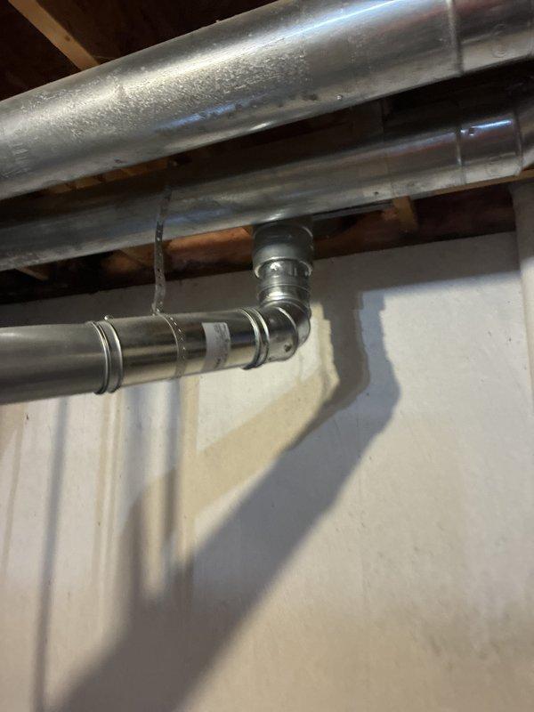 Conducted full system estimate for central air replacement on 23-year-old Amana unit. Inspected existing HVAC infrastructure including ductwork, condensate lines, and refrigerant piping showing significant condensation buildup indicating potential insulation deficiencies. Documented current system configuration in basement utility area, photographed existing metallic ductwork, PVC drain lines, and copper refrigerant lines to provide comprehensive replacement quote for immediate installation.