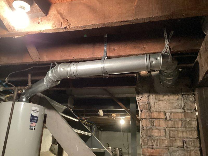Installed Bradford White tanked water heater model RG240T6N in basement location on concrete floor against masonry wall. Connected water supply lines and configured piping to top of unit, ensuring proper integration with existing plumbing infrastructure including exposed joists and ductwork systems. Permit was previously requested and all required documentation was completed for financing approval.