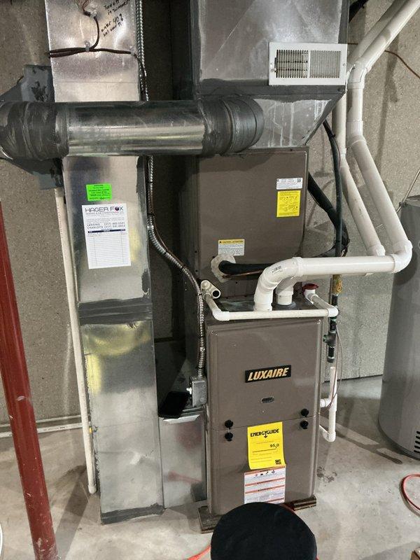 Completed annual cooling maintenance on residential Luxaire HVAC system. Inspected furnace unit, air handler, and associated ductwork for proper operation and component condition. Accessed filter compartment and documented mesh filter condition showing significant dust and debris accumulation throughout the filter media. Photographed system configuration including condensate drain lines, flexible vent connections, and electrical wiring for service records. All major components visually inspected and system operational status verified.