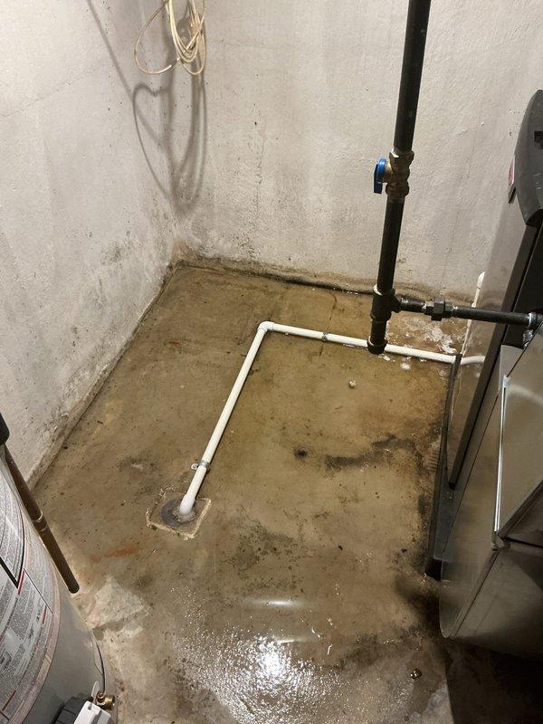 Responded to service call for water leaking from furnace during air conditioning operation on 2-year-old equipment located in basement. Upon inspection, found condensate drain line system experiencing drainage issues, resulting in water overflow onto concrete floor. Cleared blockage in condensate drain line, verified proper drainage flow through PVC piping to floor drain, and tested system operation to confirm leak was resolved. Equipment covered under parts and labor warranty.