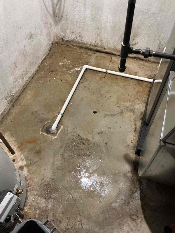 Responded to service call for water leaking from furnace during air conditioning operation on 2-year-old equipment located in basement. Upon inspection, found condensate drain line system experiencing drainage issues, resulting in water overflow onto concrete floor. Cleared blockage in condensate drain line, verified proper drainage flow through PVC piping to floor drain, and tested system operation to confirm leak was resolved. Equipment covered under parts and labor warranty.