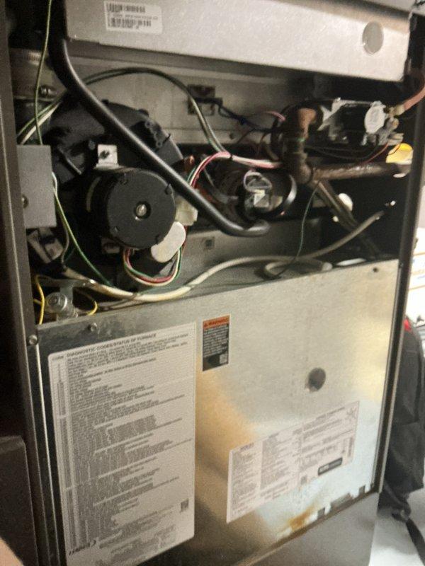 Responded to service call for water leakage from furnace occurring when air conditioning system was in operation. Upon arrival, inspected 11-year-old HVAC system located in basement. Found evidence of significant water damage and rust staining on top surface of furnace cabinet, indicating ongoing condensate drainage issue. Removed access panel and performed thorough internal inspection of furnace components, blower assembly, and condensate management system. Identified condensate drain line obstruction causing water backup and overflow onto furnace cabinet during AC operation. Cleared blockage from drain line and verified proper drainage flow. Inspected evaporator coil, drain pan, and associated plumbing connections for additional issues. Tested system operation in cooling mode to confirm water is now draining properly through condensate lines without leakage. System operating as designed with no further water discharge onto equipment.