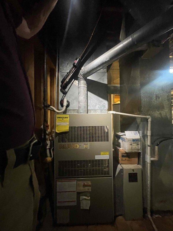 Provided comprehensive estimate for complete air conditioning system replacement in basement location with existing Ruud furnace. Current A/C unit is non-operational and requires full replacement with expedited installation timeline requested. Evaluated existing ductwork configuration, refrigerant line routing, condensate drainage system, and electrical connections to determine proper equipment sizing and installation requirements for new cooling system compatible with natural gas furnace setup.
