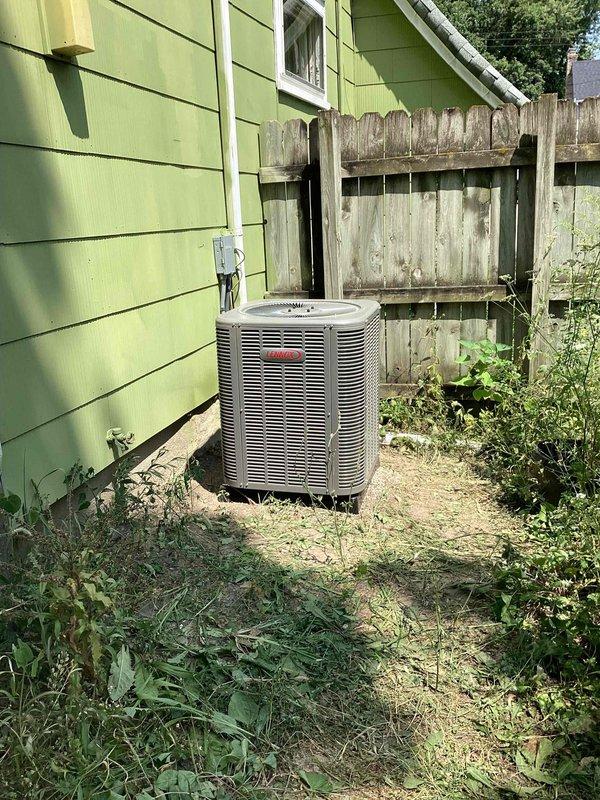Completed installation of 2-ton air conditioning system with matching evaporator coil at residential property. Positioned outdoor condenser unit on concrete pad against exterior wall with proper clearances, installed new electrical disconnect box and dedicated circuit per code requirements, and ran insulated refrigerant lines into building connecting to indoor coil. System was pressure tested, evacuated, charged to manufacturer specifications, and tested for proper operation with all electrical connections secured and condensate drainage confirmed functional.